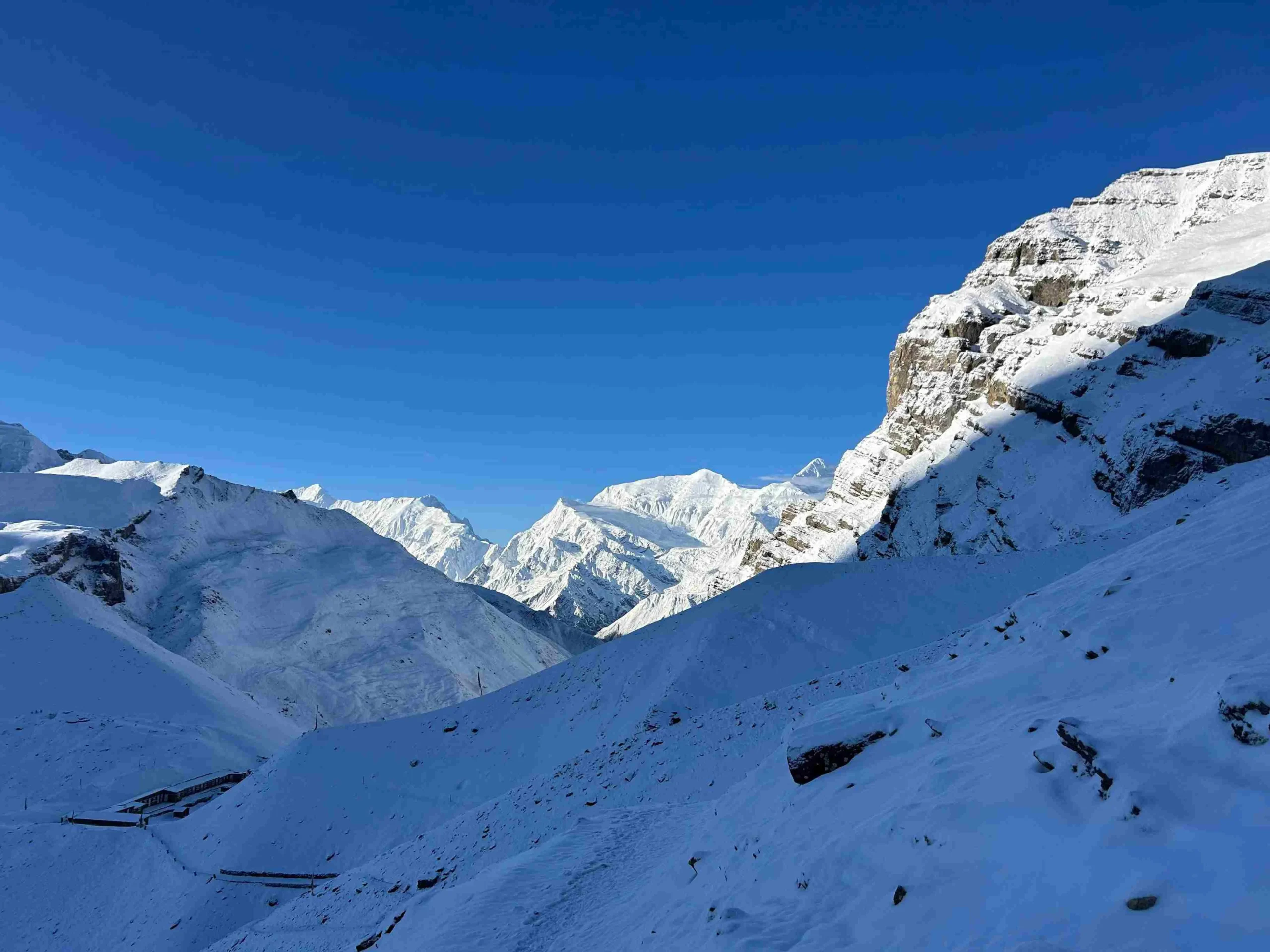 Snow-covered Annapurna mountain slopes and Himalayan peaks under a clear blue sky