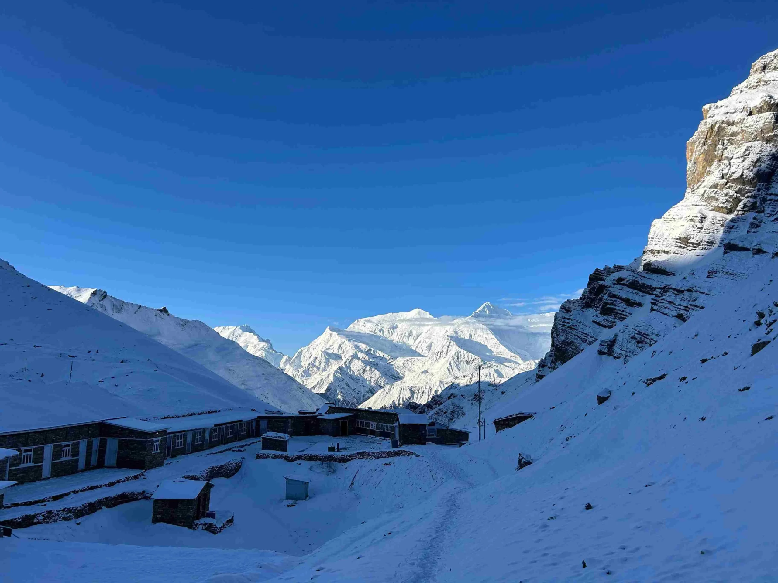 Snow-covered lodges and Himalayan peaks along the Annapurna Circuit Trek in Nepal