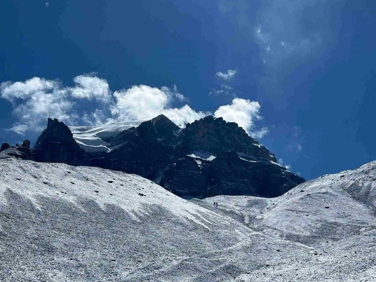 Snow-covered mountain trail in the Annapurna region under a clear blue sky